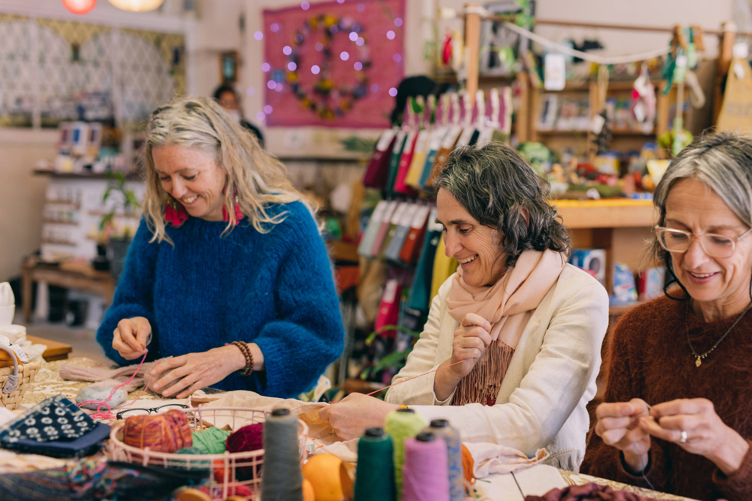 Three ladies mending in a crafting workshop